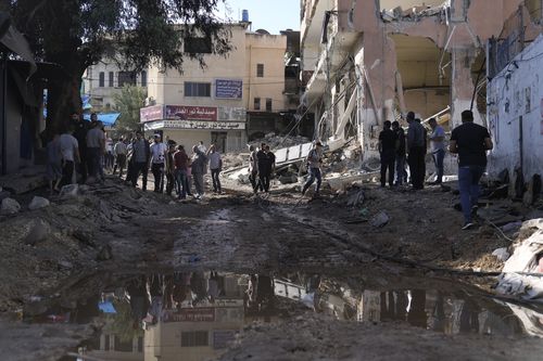 People look at destruction after an Israeli army raid on a Palestinian refugee camp, Nur Shams, in the West Bank, Friday, Oct. 20, 2023.  