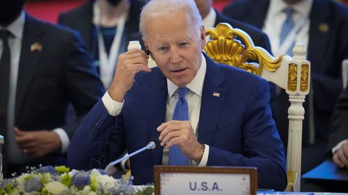 U.S. President Joe Biden adjust his earphone during the ASEAN - US (Association of Southeast Asian Nations) in Phnom Penh, Cambodia, Saturday, Nov. 12, 2022. (AP Photo/Vincent Thian)