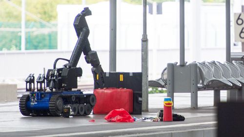 A remotely controlled bomb disposal robot approaches a red suitcase on a platform in Chemnitz Central Station in the region of Saxony, Germany on October 8. (AFP) 