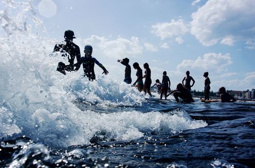 Teenagers enter the water on North Bondi Rocks at the start of the summer school holidays