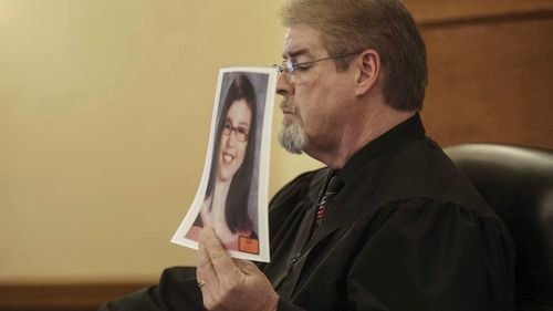 Judge Terry Rickers holds up a photo of Sabrina Ray prior to handing down a sentence to her parents, Misty Jo Bousman Ray and Marc Ray on January 18, 2019.