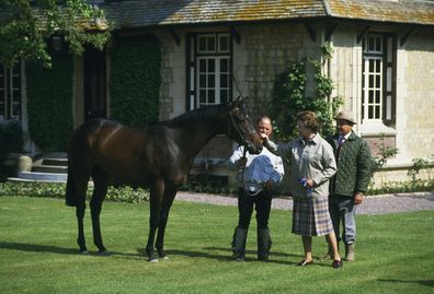 Queen Elizabeth II of Britain examines a horse at Le Quesnay horse farm near Deauville. 