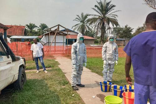 Men stand outside an Ebola treatment center in the remote Bulape Health Zone, Kasaï province, the Democratic Republic of Congo