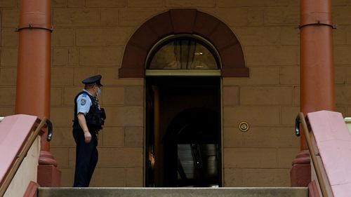 A masked officer at the entrance of NSW Parliament House after NSW Agriculture Minister Adam Marshall tested positive for COVID-19. 
