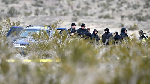 Investigators with the San Bernardino County Sheriff's Department investigate after six bodies were discovered on a dirt road in the Mojave Desert in El Mirage, California.