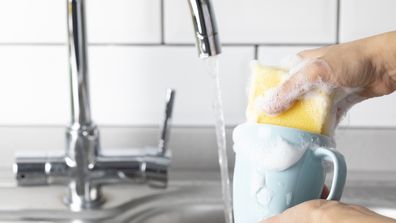 Woman is washing coffee cup.