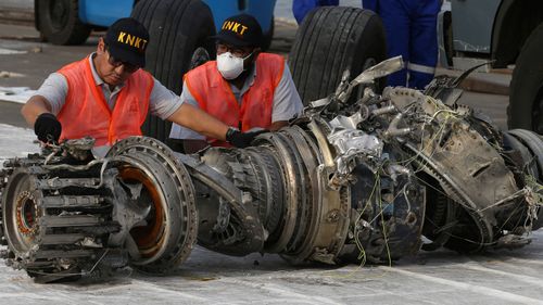 Officials inspect an engine recovered the crashed Lion Air jet in Jakarta.