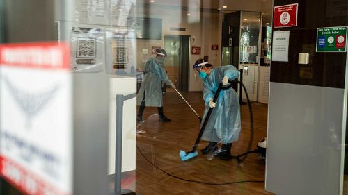 Cleaners are seen wearing full PPE while working at the disinfection of the Holiday Inn hotel.