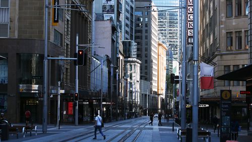 A pedestrian crosses George Street in Sydney.