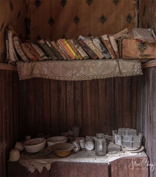 And old bookshelf with personal trinkets underneath.