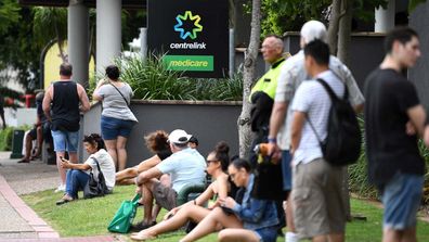 People are seen in long queues outside the Centrelink office in Southport on the Gold Coast, Monday, March 23, 2020. 