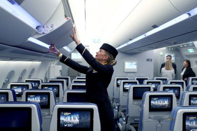 Flight attendant using overhead storage 