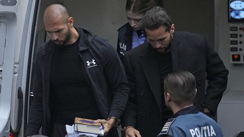 Andrew Tate, right, and his brother Tristan, left, are brought by police officers to the Court of Appeal, in Bucharest, Romania, Tuesday, Jan.10, 2023. Andrew Tate, a divisive social media personality and former professional kickboxer, was detained last month in Romania on charges of human trafficking and rape, and later arrested for 30 days after a court decision. (AP Photo/Vadim Ghirda)