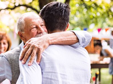 Grandfather hugging his adult grandson