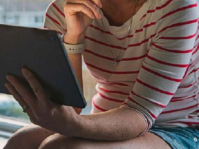 Woman sitting at home on computer sad