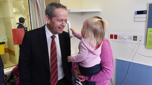 Bill Shorten gets his temperature checked by 20-month-old Katie Plowman at Casey Hospital. (AAP)