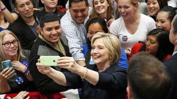 Hillary Clinton takes a selfie with supporters. (AAP)
