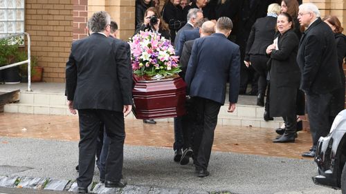 Ms Herron's casket was adorned with pink and white flowers.