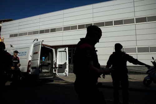 Catalan police officers stand guard outside a Police station, following an attack in Cornella de Llobregat near Barcelona, Spain