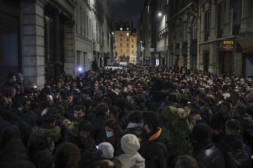 The Kurdish community gathers near the crime scene where the shooting took place in Paris, Friday, Dec. 24, 2022. A shooting targeting a Kurdish cultural center in Paris Friday left three people dead and three others wounded, authorities said. (AP Photo/Lewis Joly)