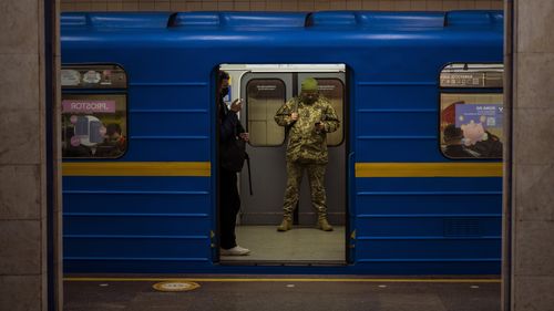 A Ukrainian army officer looks at his phone in a local train in Kyiv, Ukraine.