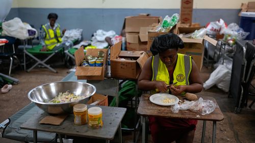 Cooks prepare meals at a shelter set up in a school ahead of Hurricane Melissa's forecast arrival in Old Harbour, Jamaica, Monday, Oct. 27, 2025. (AP Photo/Matias Delacroix)