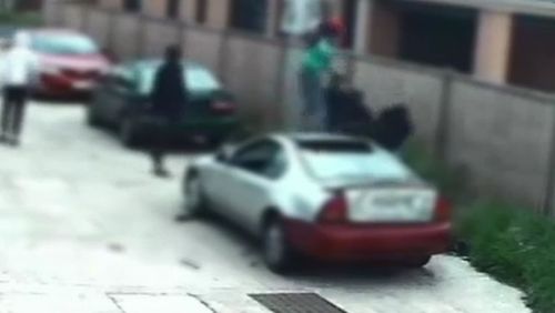 One of the attackers climbs onto a car bonnet to jump onto the victim.