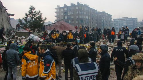 People and rescue teams try to reach trapped residents inside collapsed buildings in Diyarbakir, Turkey, Monday, Feb. 6, 2023.  