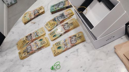 Two men have been charged after police uncovered $130,000 in cash, drugs, nun-chucks and luxury watches during early morning raids across Sydney. 