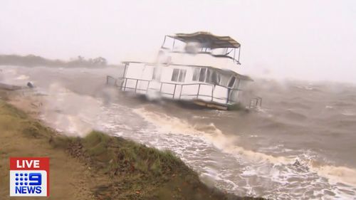 A houseboat washed ashore and stranded in waters off Queensland.