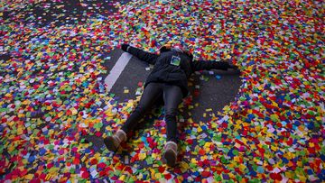 Jaclyn Bernstein, of New York, lies in confetti after the Times Square New Year&#x27;s Eve Ball dropped in Times Square.