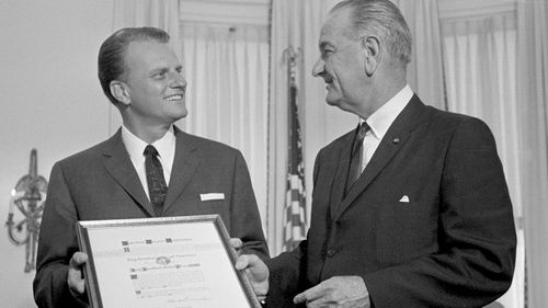 President Lyndon Johnson presents the Man of the Year award of the Big Brothers organization to evangelist Billy Graham at the White House in Washington. (AAP)