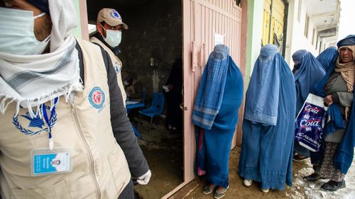 Women line up as the UN World Food Program distributes a critical monthly food ration, largely supplied by USAID, to 400 families south of Kabul, Afghanistan, in January 2022.