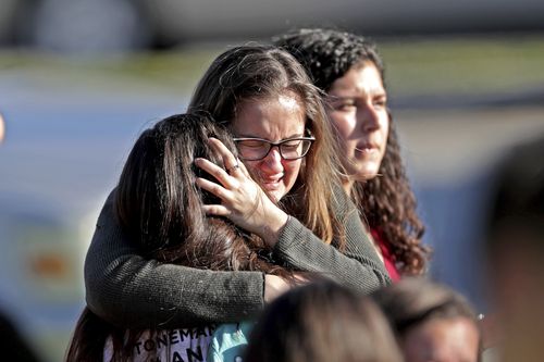 Students released from the lockdown embrace following the shooting. (AAP)