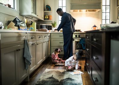 Father cooking breakfast for daughters in kitchen