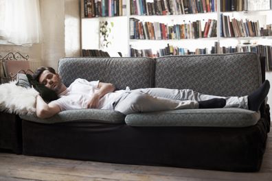 Man sleeping on sofa in cozy loft apartment