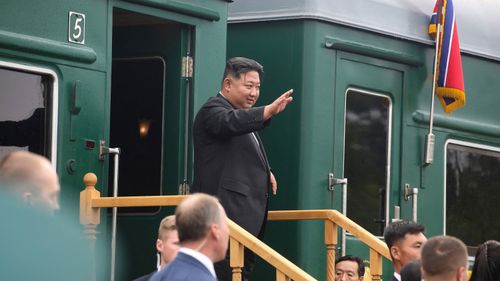 Liderul nord-coreean Kim Jong Un face semn cu mâna în timp ce se urcă în trenul său într-o gară din orașul Artyom pentru a părăsi Rusia duminică.