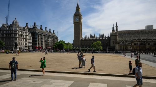 Tourists walk in the sunny Parliament Square on July 14, 2022 in London, England. 
