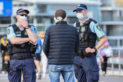 New South Wales police officers talk to locals on the beach promenade as part of their high profile compliance patrols at Bondi Beach on August 10, 2021.