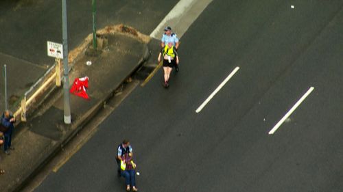 Protesters being dragged off the Spit Bridge by police officers after blocking the road and disrupting peak hour traffic.