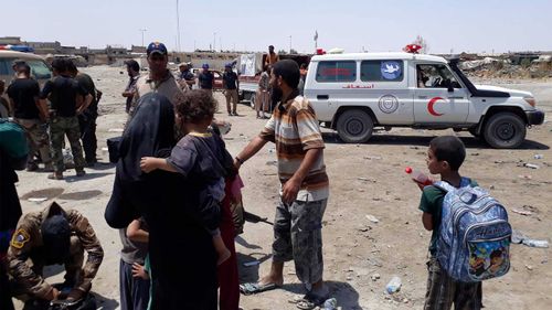 Mosul residents near a Red Crescent vehicle. (Owen Holdaway)