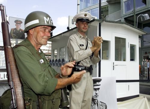 Two unidentified Germans dressed like US-Military Police pose during the openig ceremony in front of an original copy of the first border control house at the Checkpoint Charlie in Berlin Sunday, August 13, 2000.