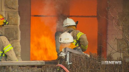 The brush fence of the Norwood home also caught fire. (9NEWS)