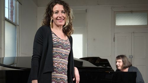 Director Jodee Mundy poses for a photo as deafblind performer Michelle Stevens plays piano on August 16, 2016 in Melbourne, Australia. Her current show 'Imagined Touch' features actors who are deaf and blind.