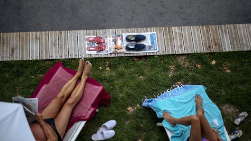 In this July 28, 2020, file photo, people sunbathe along the river Seine in Paris.