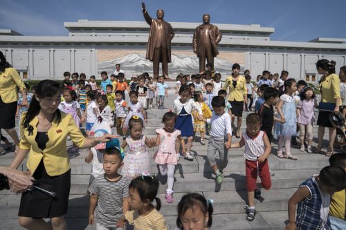 Children leave after paying their respects in front of bronze statues of the late leaders Kim Il Sung, left, and Kim Jong Il at Munsu Hill in Pyongyang, North Korea, Saturday, July 7, 2018. North Korea marks the anniversary of Kim Il Sung's death on July 8. (AP Photo/Andrew Harnik, Pool)
