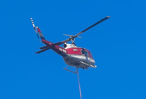 Phil O'Driscoll's UH-1H helicopter waterbombing the Holsworthy blaze on the weekend. (AAP) 