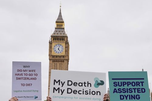 Banners are held by pro-assisted dying campaigners as they gather outside Parliament in London, May 15, 2025 