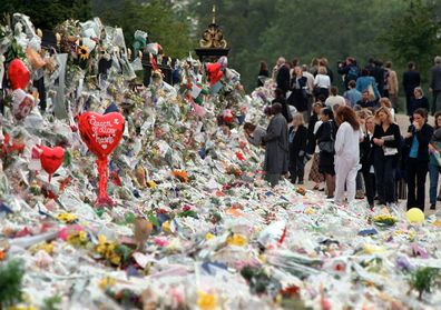 Mourners file past the tributes left in memory of Diana Princess of Wales at Kensington Palace in London, Friday, September 5, 1997.  