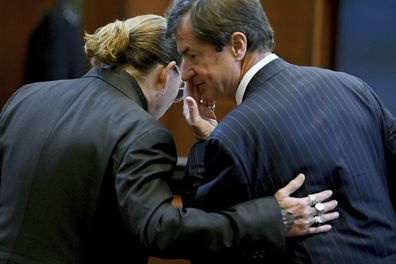 US actor Johnny Depp speaks to his attorney Ben Chew in the courtroom at the Fairfax County Circuit Court in Fairfax, Virginia, on May 3, 2022.